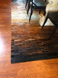 Okay, this area rug is made of tiny strips of different colored COW HIDE! You almost don't wanna walk on it! It's wall-handing worthy!