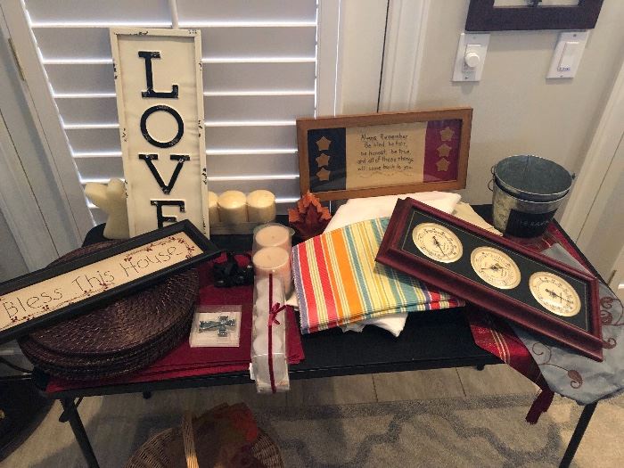 Table full of goodies. Linens. Placemats. Decorative items for the wall