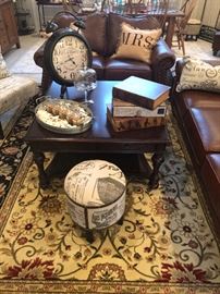 This is a fun room. The family room or den. Beautiful rug under a contemporary square coffee table. Fun decorative objects and one of two matching stools. Just a peek at the matching love seat and sofa in soft supple leather