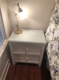 a wood wicker side chest or night stand with a cute brass lamp