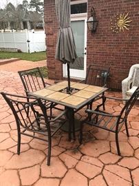 an outdoor iron table with chairs and umbrella. we have the nice like new cushions too