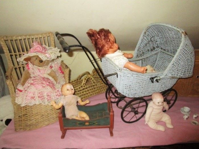 Dolls, antique wicker potty chair and wicker buggy
