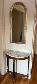 Small, demi-lune marble-top table with arched mirror. 