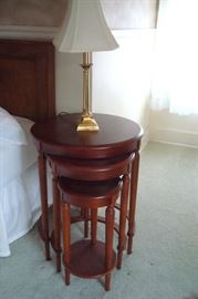 One of a set of round mahogany nests of tables and one of a pair brass table lamps.