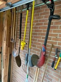 Yard tools including weed eater, shovel, rakes, hoes and more.