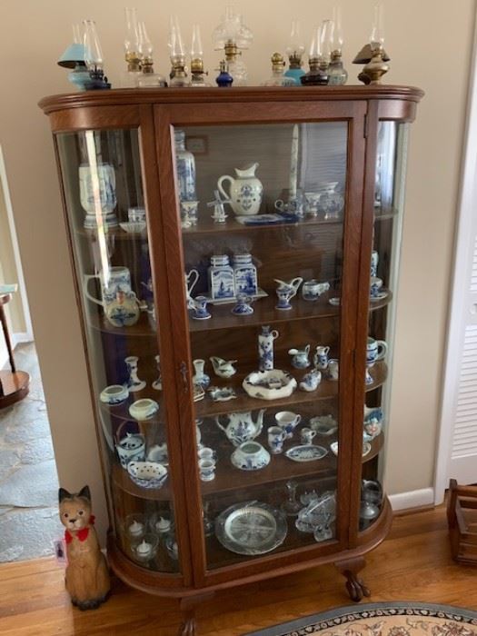 Large collection of collectible items including oil lamps and blue china.