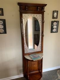 Antique coat rack with marble top and mirror.