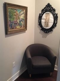 Framed artwork. Grey comfy chair. 