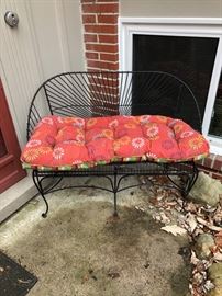 Wrought iron bench and cushion.