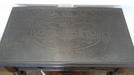 Etched brass panels on top and on front of the drawers. Theodore Alexander table.