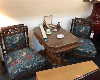 Hand carved wooden upholstered side chairs with flowers & birds. Casters on front 2 legs of both chairs. Very well made & loved  with matching table in between