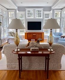 Console table with a matching pair of amber glass lamps.