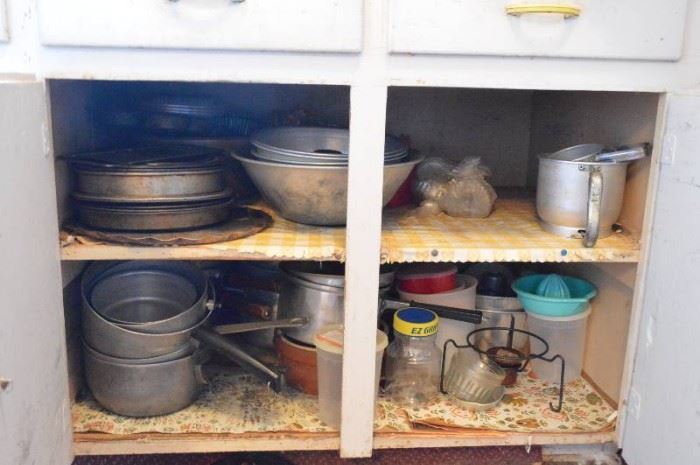All kitchenware dishes in lower cabinets two d ...