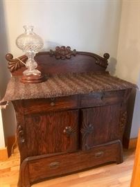 Ornate Antique Wooden sideboard with carved details and pulls on drawers and cabinets