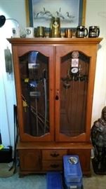 Gun cabinet with swords, fencing swords and scabbards, military mugs on top