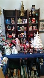 Various Christmas decorations with another white lighted ceramic Christmas tree, books, etc.