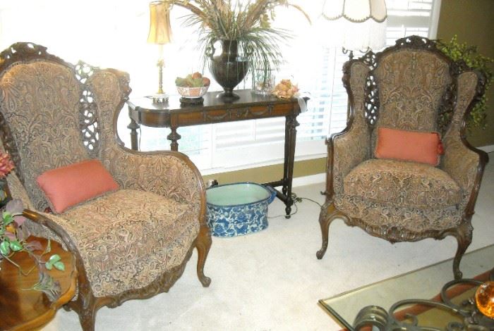Early 20th century tufted wingback chairs with pierced carved wood dragons and busts of Minerva by Imperial.