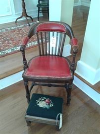 Captain's chair with red leather and needlepoint topped foot stool