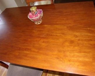 Bar height table with center pull-out leaf and 6 chairs with light gray padded seats, in excellent condition.