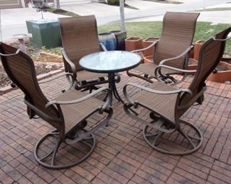 4 rocker/swivel chairs. Glass top patio table. Pottery not for sale.