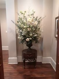 Monumental floral arrangement with silk flowers and greenery on small round stand