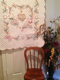 Quilt; small antique chair; large floral arrangement