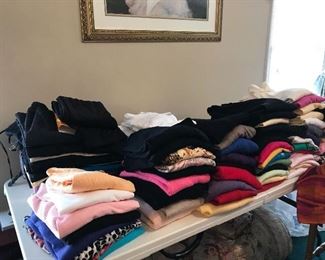 Many ladies turtle neck tops and other pullover tops in various colors.