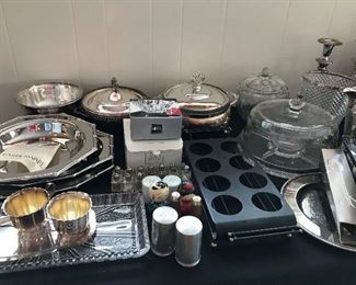 Tables full of decor, serving ware, silver plated ware, glassware, stainless steel and more.