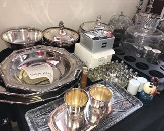 Tables full of decor, serving ware, silver plated ware, glassware, stainless steel and more.