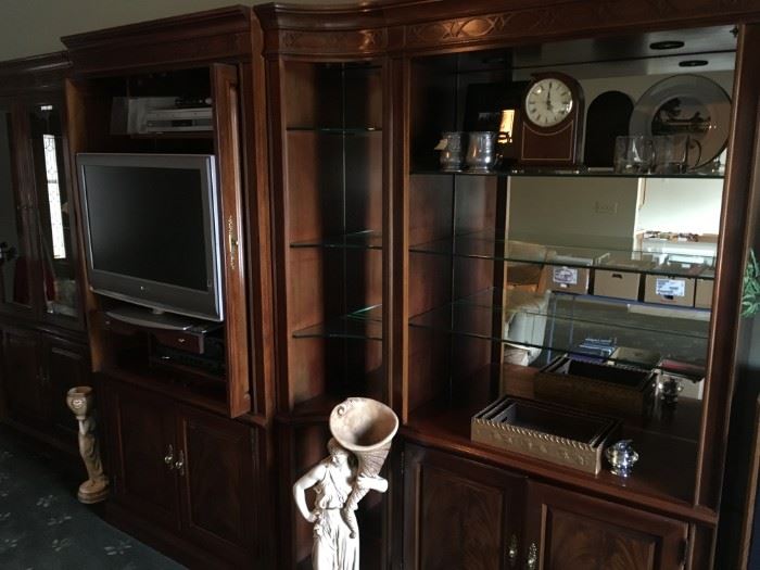 Accent door front panels,  curve side units, and recess lighting make this wall unit upscale elegant in style.