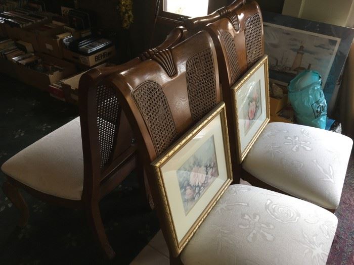 Thomasville fine wood and cane back dining chairs. With framed art work here and there.