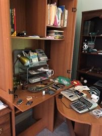 Computer hutch closes up. Office lamp, calculator with tape and office supplies.