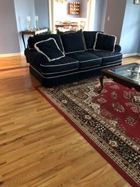 Blue cordoroy couch and large rug.