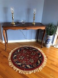 Foyer table, electric hurrican lamps and small round rug.