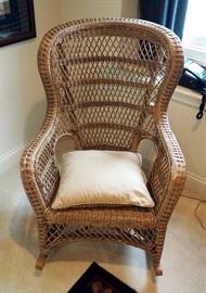 High Back Wicker Rocking Chair With Woven Stick Basket And Assorted Childrens Books