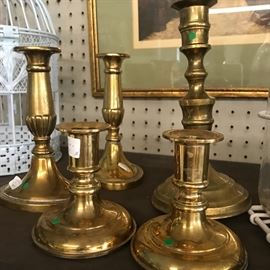 many brass candlesticks all sizes