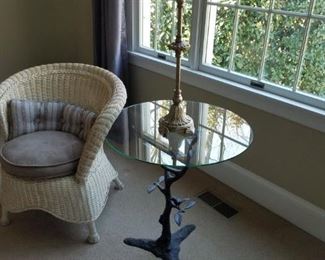 wicker chair with glass-top & metal base table (bird/tree branch detail on base)