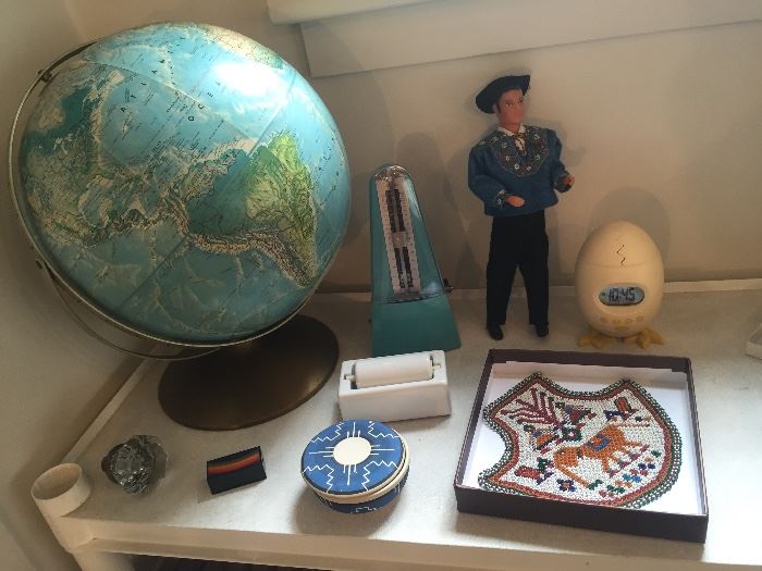 Vintage globe, turquoise wind-up metronome, Sioux pottery round box, Schweitzer male doll, chicken/egg alarm clock, beaded panel with elephant