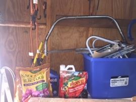 Garden fertilizers, bow saw, bungie cords, metal wall hanging clamps about 10 pairs