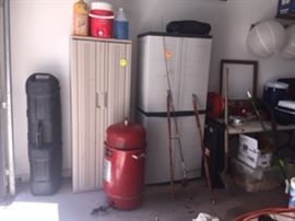Rubbermaid shelves, red electric smoker, golf bag travel case, made in japan cane fishing poles, coolers