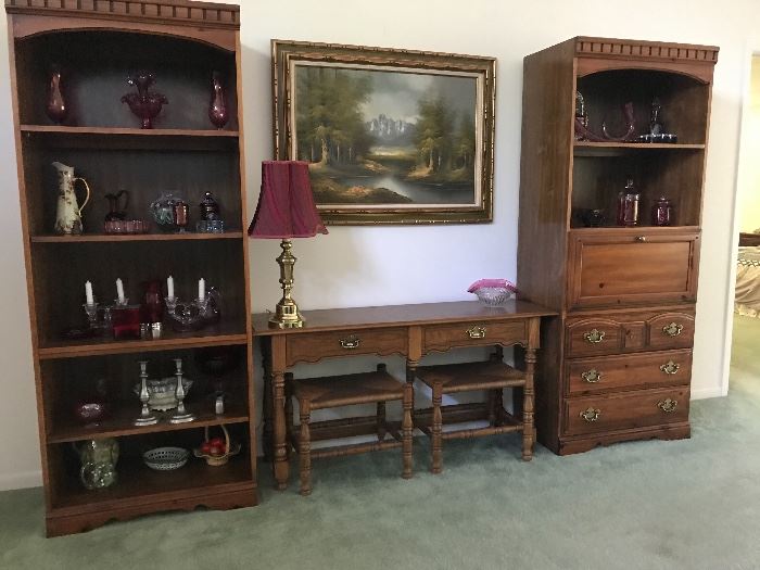 Two bookcases.  The center piece of furniture is a sofa table with two stools.