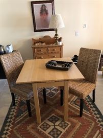 Two rattan straight back chairs and small table. Woven rug