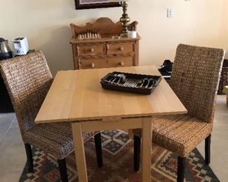 Two rattan straight back chairs and small table. Woven rug