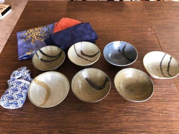 A collection of stoneware bowls and table linens