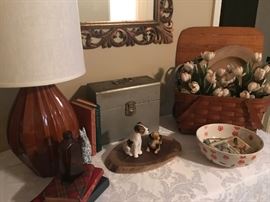 Gilded wall mirror, table lamp, picnic basket, books, and more.