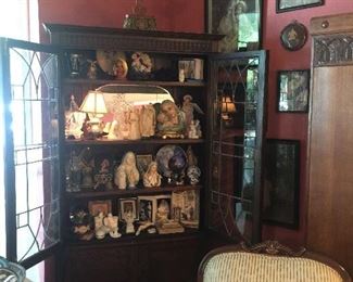 The formal living room, lead glass china cabinet, upholstered arm chair with footstool, vintage prints