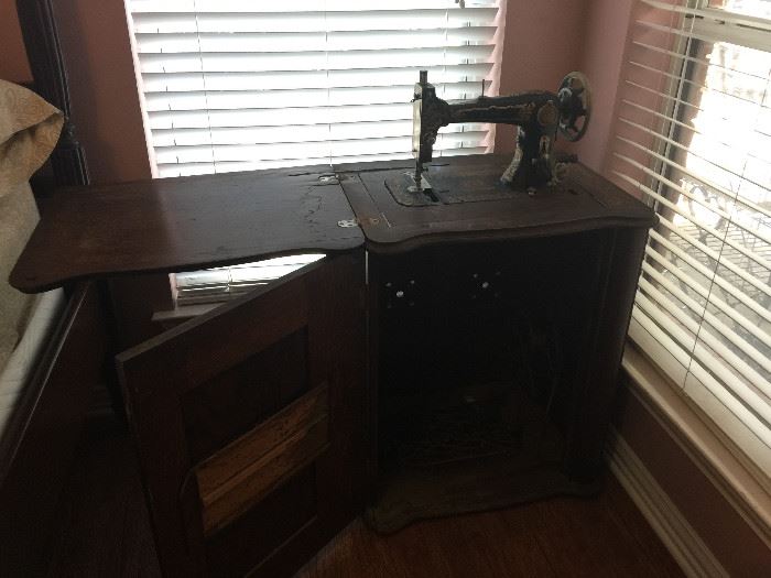 The cabinet open showing the treadle showing machine