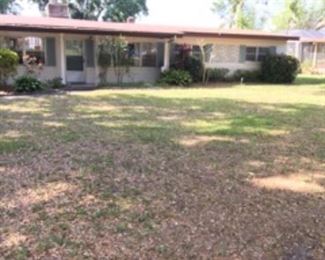 FRONT EXTERIOR OF LAKEFRONT HOME FOR SALE. ON LAKE CONWAY. BEAUTIFUL LOT WITH AWESOME LAKE FRONTAGE. GREAT BUY!