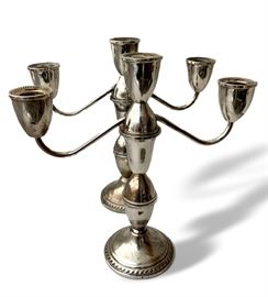 Pair of Sterling silver cement filled candlesticks.  Shows wear and dents. 9 ½” tall x 9 ½” across, 3 ½” at base. 
