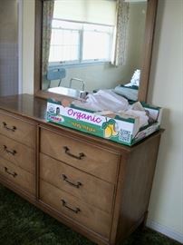 small dresser with mirror and linens